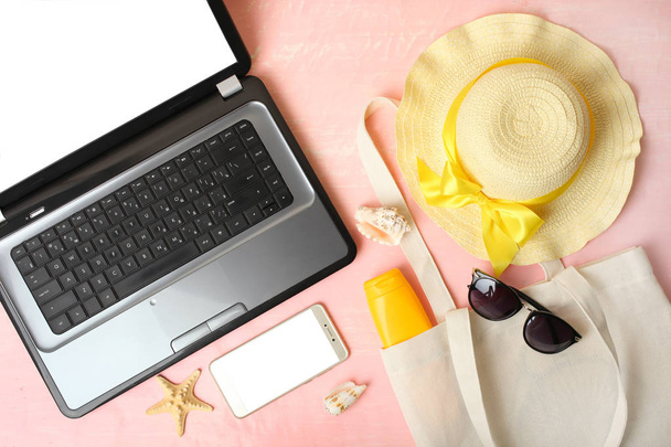 Accesorios de playa, laptop y smartphone sobre fondo rosa
. - Foto, imagen