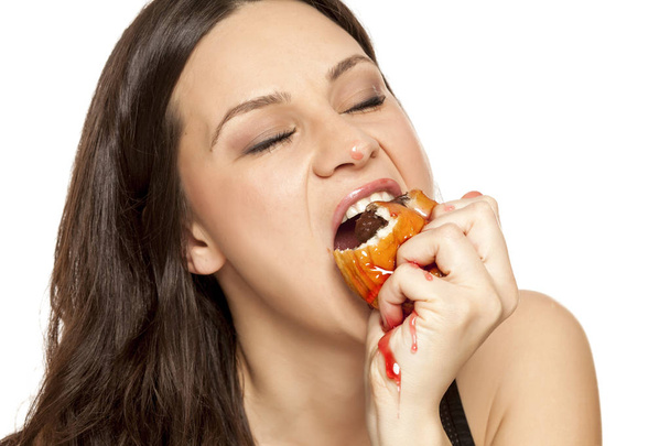 Himo nuori nainen syö kirsikka keveiden donitsi valkoisella pohjalla
 - Valokuva, kuva