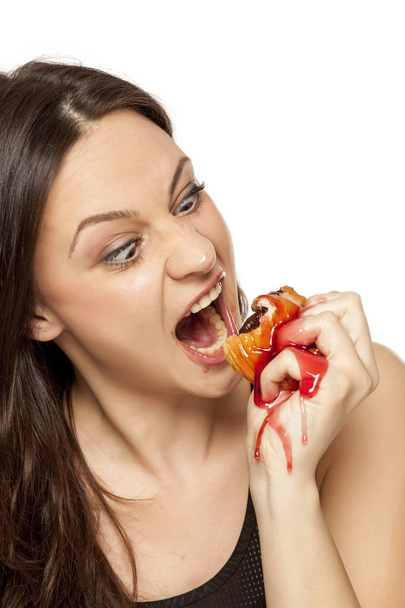 白い背景にドーナツをトッピングに桜を食べる若い女性を渇望 - 写真・画像