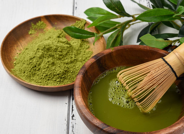Japanese green tea matcha in a wooden bowl. - Фото, изображение