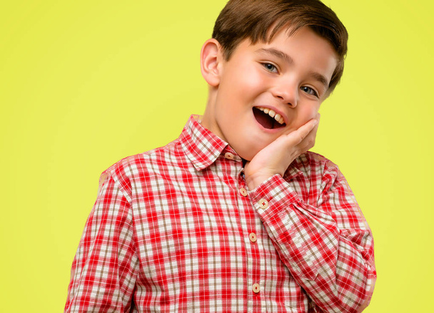 Beau tout-petit enfant avec les yeux verts heureux et surpris acclamations exprimant wow geste sur fond jaune
 - Photo, image