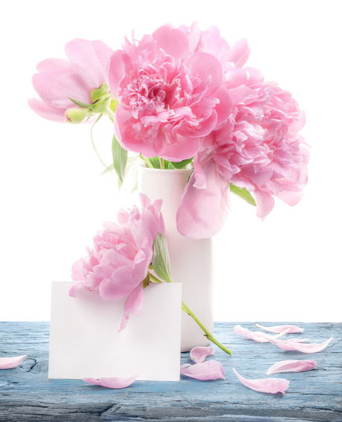 Bouquet of peonies flowers in white vase with paper blank isolated on white - Foto, imagen