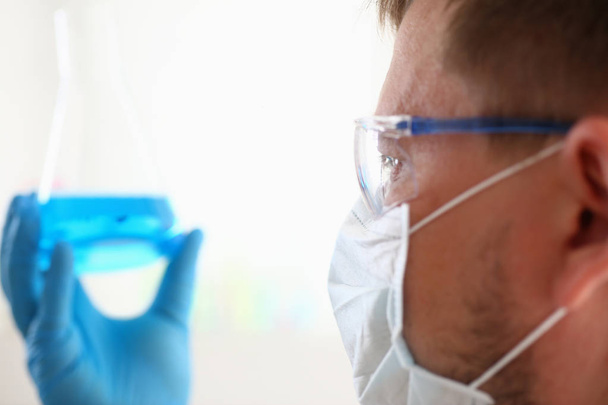Un químico masculino sostiene tubo de ensayo de vidrio en
 - Foto, Imagen