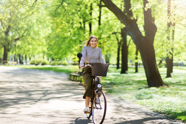 Привлекательная молодая женщина на велосипеде по парку
 - Фото, изображение