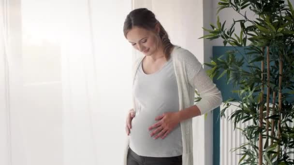 Pregnant woman looking through window - Video