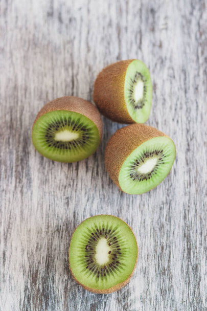 Green kiwis on the wooden background, soft focus background - Foto, afbeelding