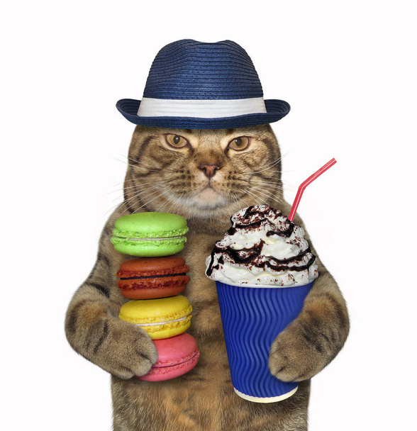 The cat in a hat holds a blue balloon, a cup of coffee and a stack of cookies. White background. - Photo, Image