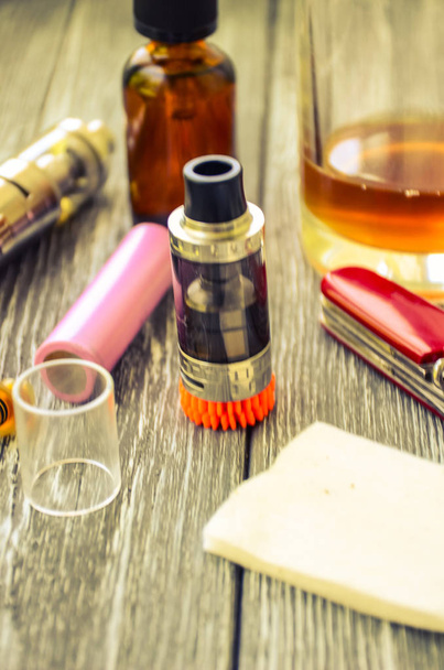 Still life with e-cig and jiuce on the wooden background - Photo, Image