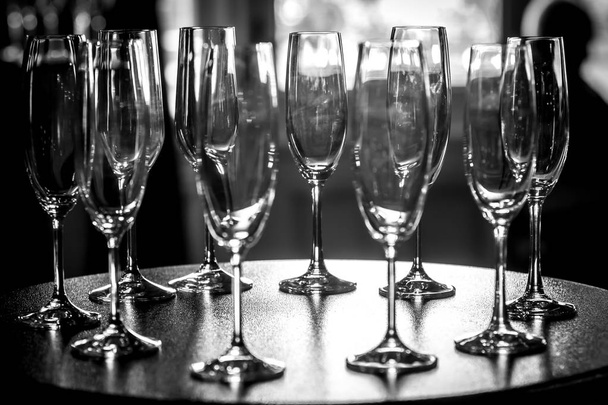 A black and white view of a group of champagne glasses arranged on a table. - Photo, Image