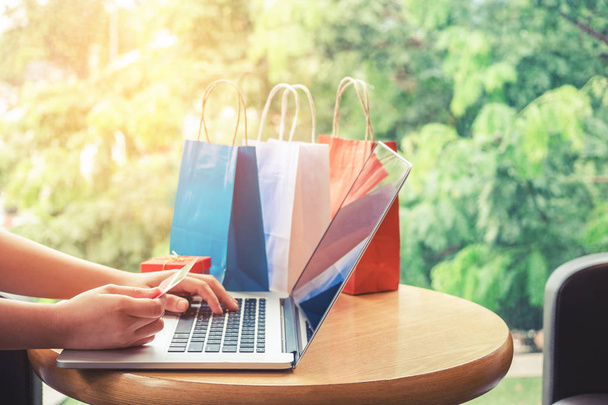 Woman shopping online using laptop with credit card enjoying - Foto, imagen