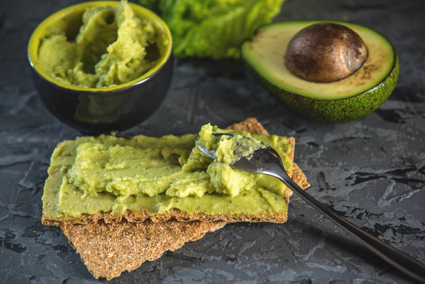 Traditional Mexican cold appetizer made of pureed avocado pulp with bread and vegetables on the table. Concept green healthy vegetarian Breakfast - Foto, Bild