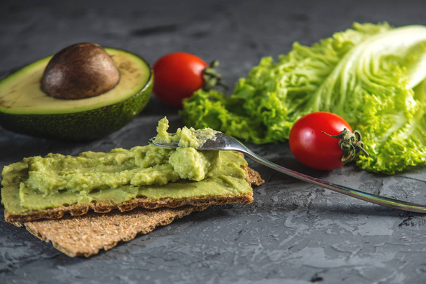 Traditional Mexican cold appetizer made of pureed avocado pulp with bread and vegetables on a dark background. Concept healthy vegetarian Breakfast - Photo, Image