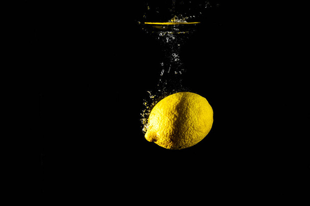 Cytryny spadek wody czarne tło - Zdjęcie, obraz