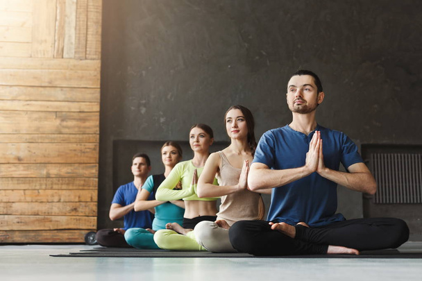 Young women and men in yoga class, relax meditation pose - Photo, Image