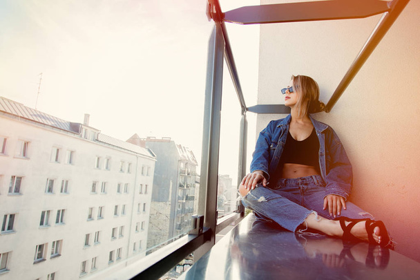 chica en jeans ropa y gafas de sol en balcón
 - Foto, Imagen