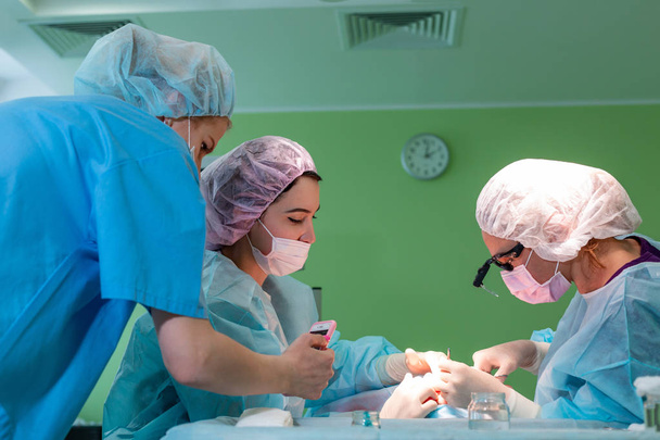 Хирурги оперируют пациента в операционной
 - Фото, изображение