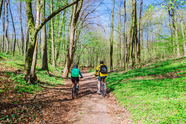 couple riding bicycle in forest in warm day - Photo, Image