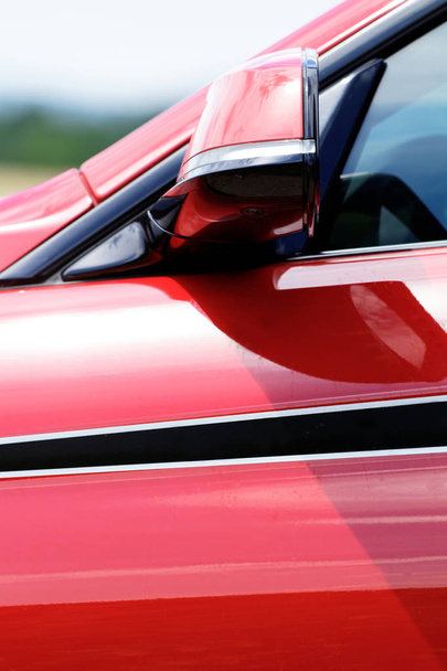 Деталь на горячем красном спортивном автомобиле - боковое зеркало заднего вида
 - Фото, изображение