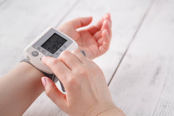 woman measures to herself arterial blood pressure, hands close-up - Fotografie, Obrázek
