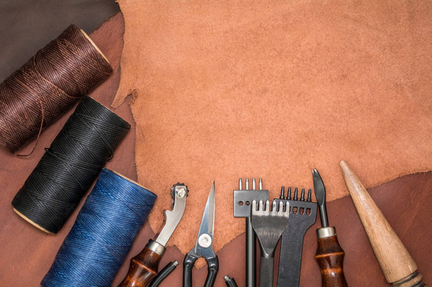 Layout of natural leather, tools for creating products and bobbins of wax yarns - Foto, Imagem