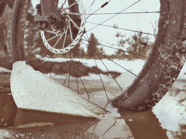 Extreme low ankle close view to mountain bicycle blocked in snowy icy trail.  Extreme wide view - Photo, Image