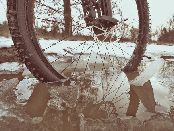 Neige hivernale à vélo de montagne. Météo extrême, route glissante sur le terrain, cheville basse vue large sur la roue avant
.  - Photo, image