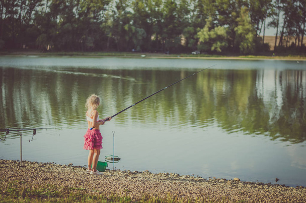 chica encantadora con caña de pescar en el estanque
 - Foto, Imagen