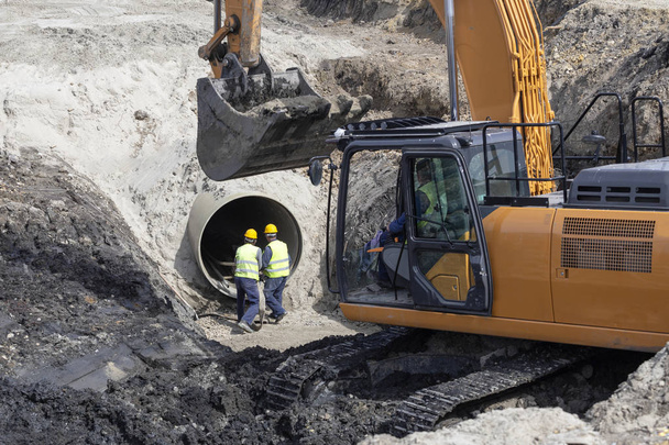 Bagger und Arbeiter machen Grabenbett für Pipeline-Neubau. - Foto, Bild
