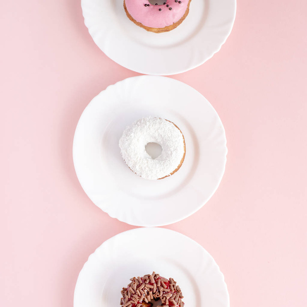 Donuts cubiertos con esmalte en platos blancos
  - Foto, Imagen