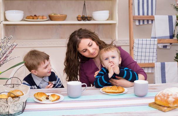 Madre y dos niños en la cocina desayunando. Feliz tiempo en familia. Madre e hijos desayunando. Concepto de familia feliz y comida saludable
. - Foto, Imagen