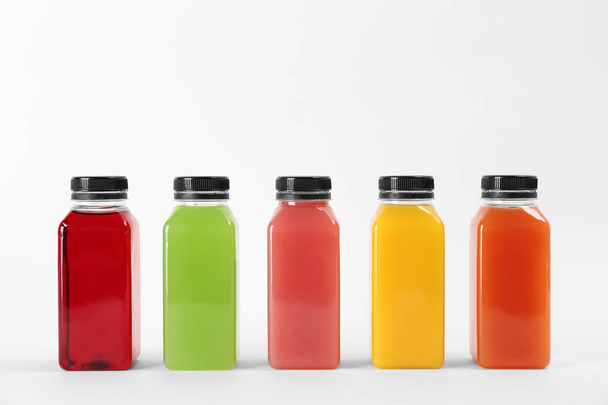 Bottles with delicious colorful juices on white background - Foto, immagini