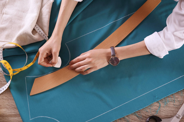 Tailor working with cloth at table in atelier, top view - 写真・画像
