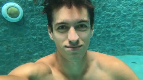 Uomo che fa selfi mentre si tuffa in piscina. Nuoto subacqueo. Guy nuota nel bacino
 - Filmati, video