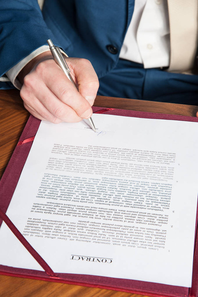teken het contract / de manager tekent het officiële contract op de overeenkomst tussen de partijen - Foto, afbeelding