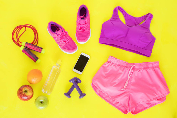 Verschiedene Workout-Essentials auf gelbem Boden - Foto, Bild