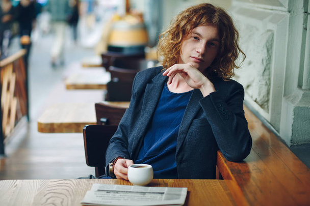 Portrait reddish hipster man with coffe and newspaper - Photo, Image