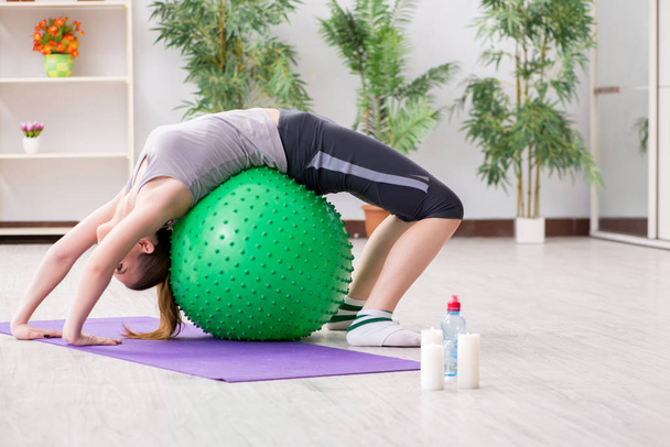 Mujer joven haciendo ejercicio con pelota de estabilidad en el gimnasio - Foto, imagen