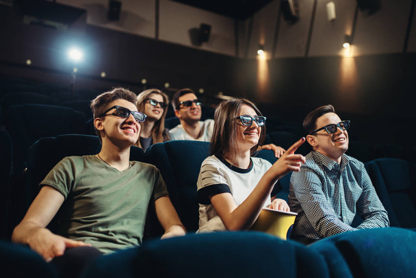 People in 3d glasses with popcorn and drinks watching movie in cinema. Entertainment business - Foto, Imagen