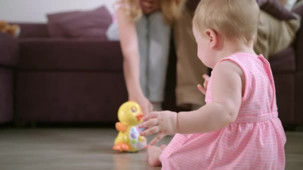 Infant playing with toy on floor. Sweet baby enjoy walking in room - Video