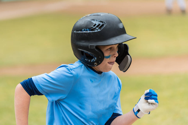 Zbliżenie na little league baseball graczy twarz Wyświetlono oko czarny i koncentracji pozycji do pierwszej bazy. - Zdjęcie, obraz