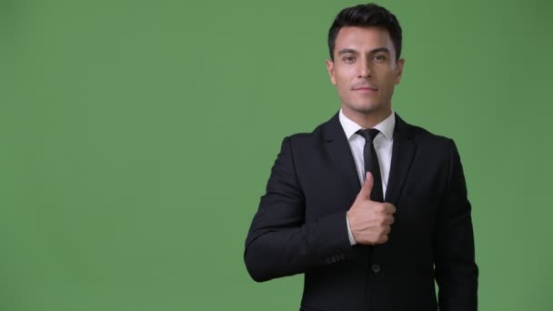 Jonge knappe Hispanic zakenman tegen groene achtergrond - Video