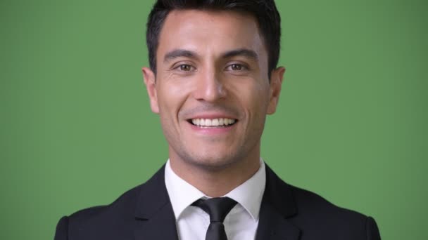 junger hübscher hispanischer Geschäftsmann vor grünem Hintergrund - Filmmaterial, Video