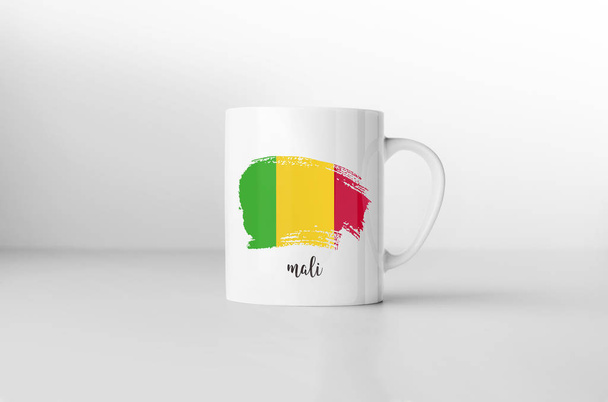 Taza de recuerdo de bandera de Malí sobre fondo blanco. Renderizado 3D
. - Foto, imagen