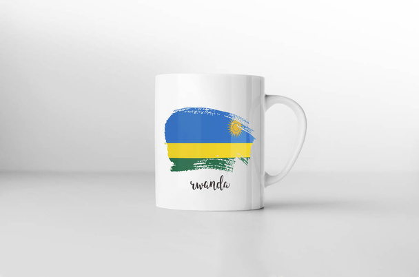 Taza de recuerdo de la bandera de Ruanda sobre fondo blanco. Renderizado 3D
. - Foto, imagen