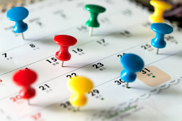 Pulgar clavijas tack en el calendario como recordatorio
 - Foto, Imagen