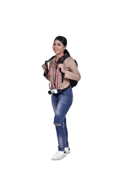 Portrait of asian traveler woman with camera and backpack standing isolated over white background - Photo, image