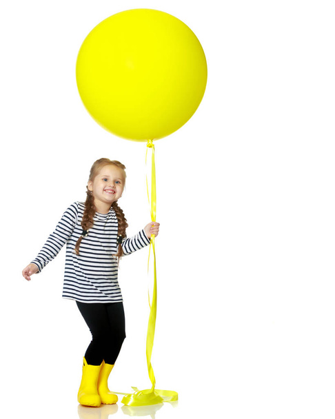 Little girl is playing with a balloon - 写真・画像