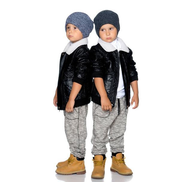 Two little boys in black jackets and hats. - Fotoğraf, Görsel