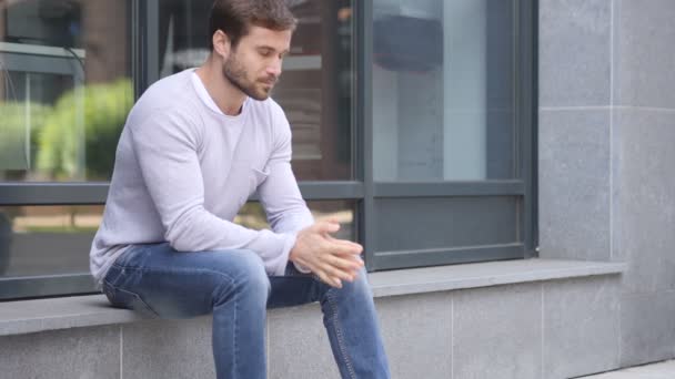 Daumen runter von gutaussehendem Mann, der vor dem Bürofenster sitzt - Filmmaterial, Video