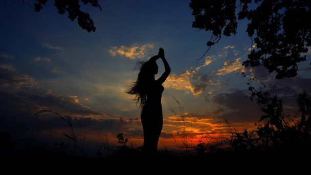 Silhouette féminine noire faisant du yoga et méditant dans le ciel du soir
. - Photo, image